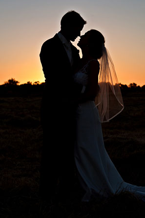sunset silhouette of bride and groom