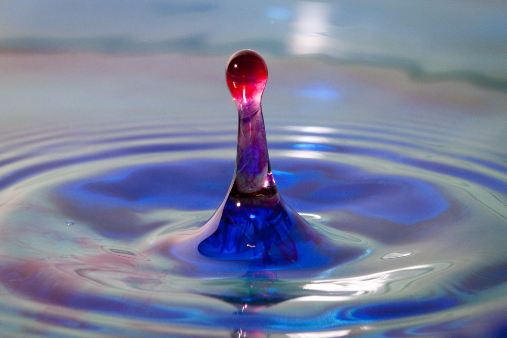 red water dropping into blue water