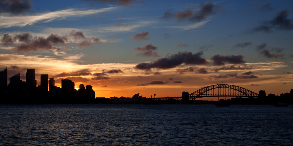 sun setting behind Sydney city