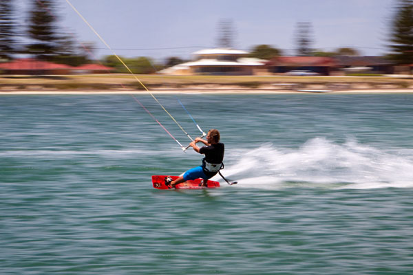 a kite surfer speeding along the water