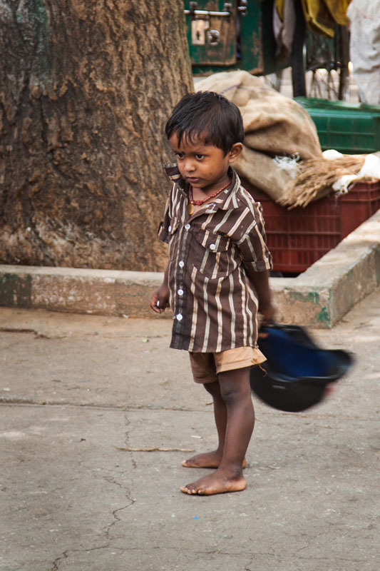 a young boy plays with a motorbike helmet