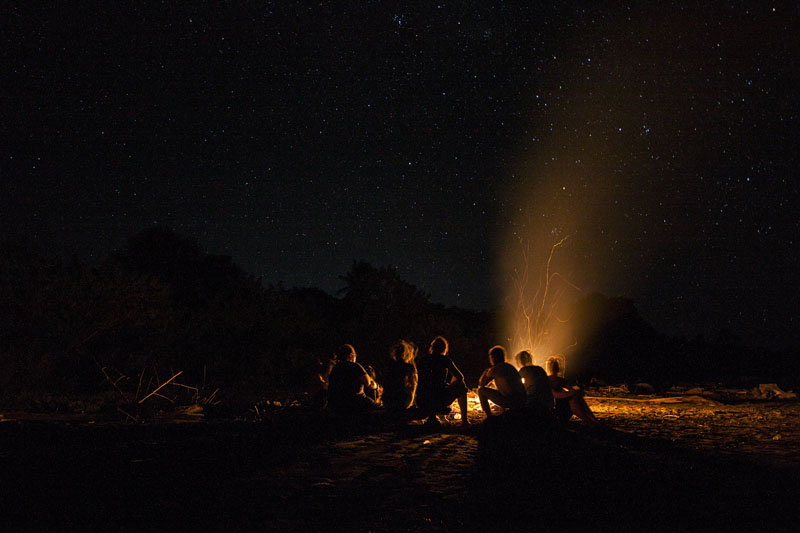 sitting around the bonfire at the beach